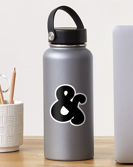 Metal water bottle sitting on a desk surrounded by a laptop and cup filled with pencils.